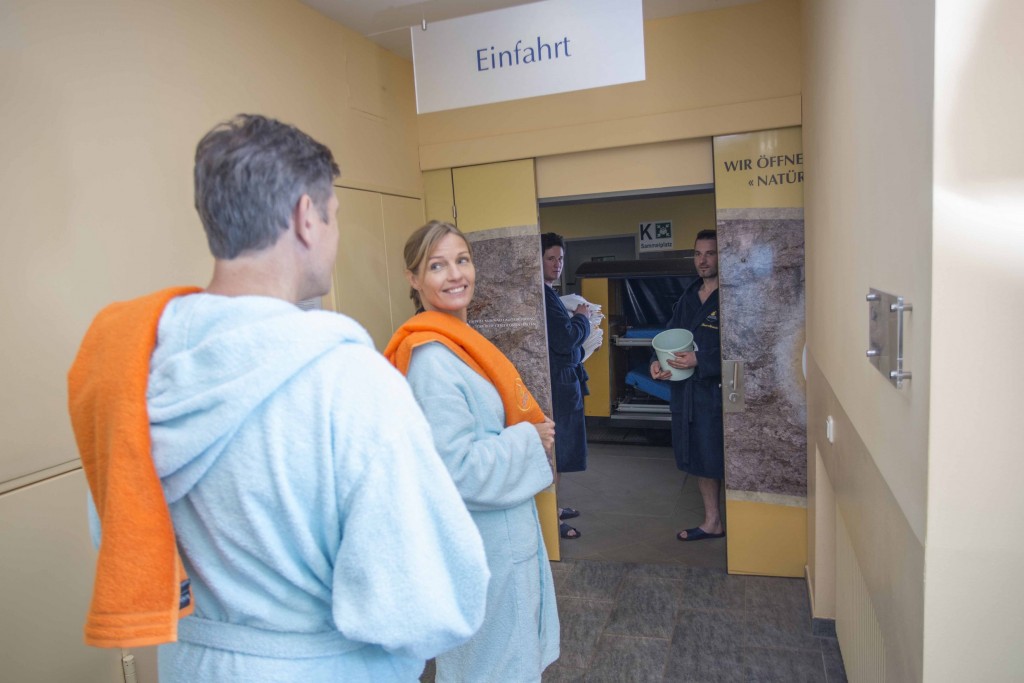 People in bathrobes wait at the entrance of the Gastein Heilstollen